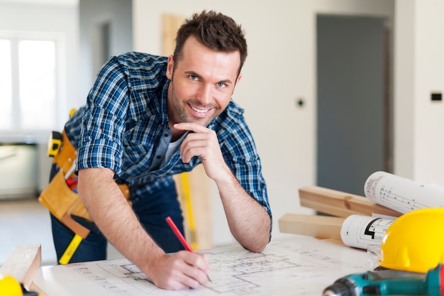 Retrato de trabajador de la construcción con planes