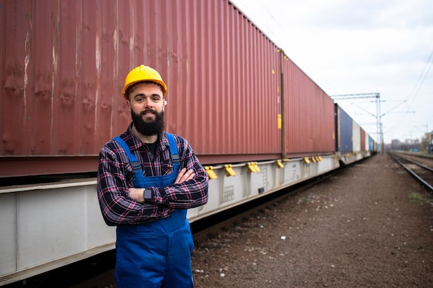 Retrato de trabajador en la estación de tren de mercancías despachando contenedores de carga para empresas navieras