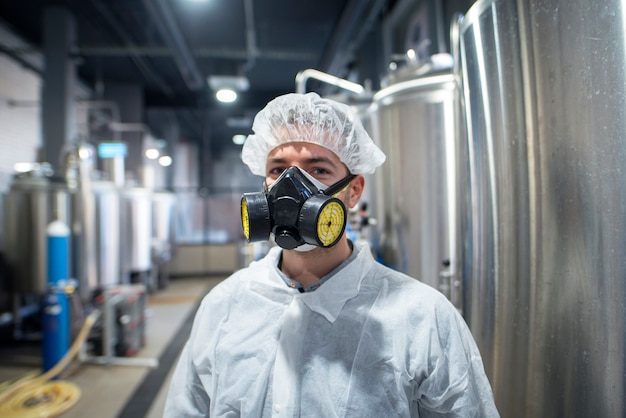 Retrato de trabajador industrial vistiendo uniforme protector y máscara de gas