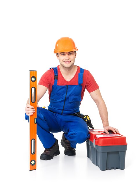 Retrato de trabajador manual sonriente con herramientas aisladas en blanco