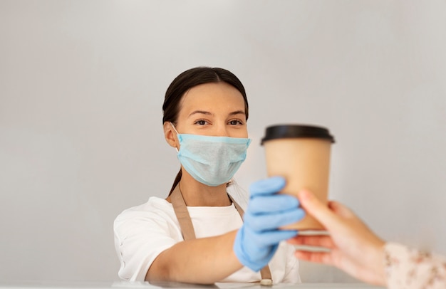 Retrato de trabajador con mascarilla y guantes quirúrgicos