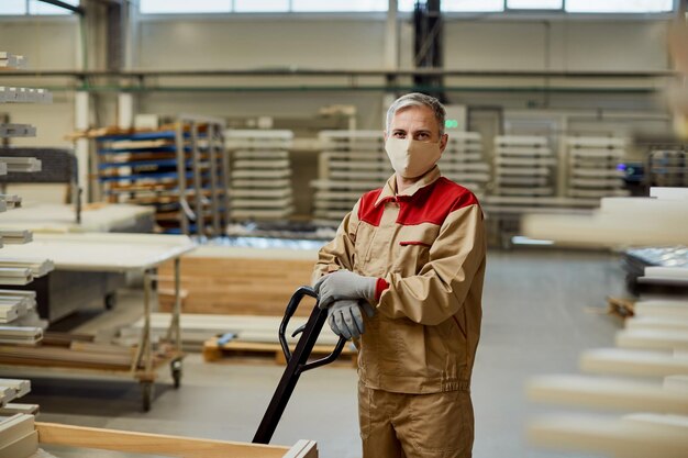 Retrato de un trabajador con mascarilla protectora en el taller de carpintería