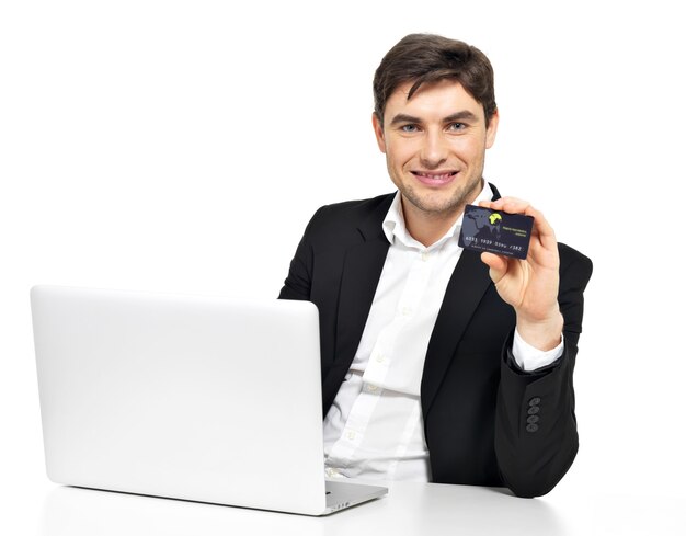 Retrato de trabajador de oficina con ordenador portátil y tarjeta de crédito sentado en la mesa aislada en blanco.