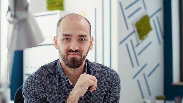 Retrato de un trabajador de oficina sentado en el escritorio para crear un informe comercial con estadísticas de ventas y gráficos financieros. Asistente ejecutivo que utiliza la investigación de datos para la presentación de empresas emergentes. De cerca.