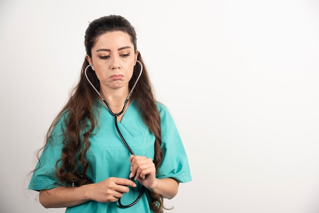 Retrato de trabajadora sanitaria molesta posando con estetoscopio.