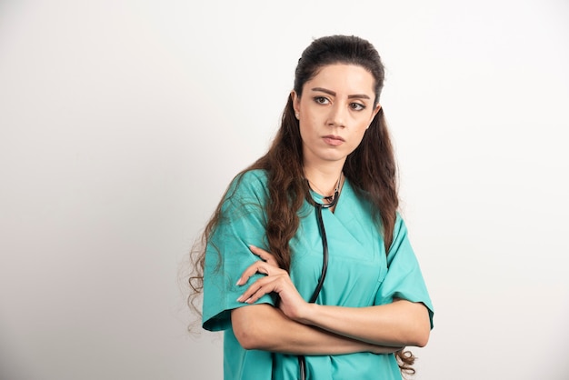 Retrato de trabajadora sanitaria posando con las manos cruzadas.