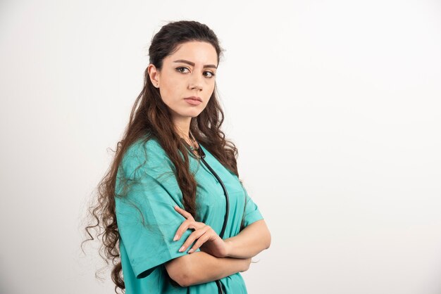 Retrato de trabajadora sanitaria posando con las manos cruzadas.