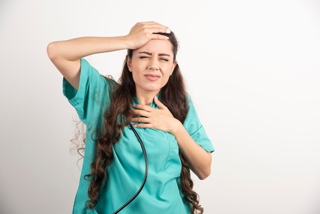 Retrato de trabajadora sanitaria tocando su cabeza.