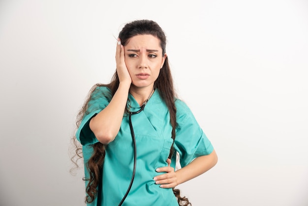 Retrato de trabajadora sanitaria tocando su cabeza.