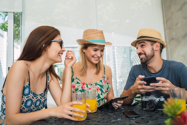 Retrato de tres amigos viajeros que pasan un rato y organizan su viaje en el hotel. Concepto de viajes y estilo de vida.