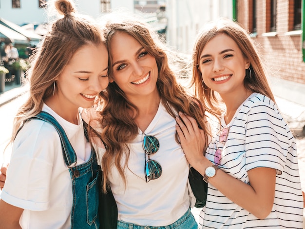 Retrato de tres jóvenes hermosas chicas hipster sonrientes en ropa de moda de verano. Sexy mujer despreocupada posando en la calle. Modelos positivos divirtiéndose