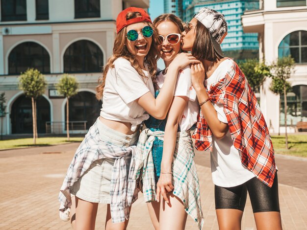 Retrato de tres jóvenes hermosas chicas hipster sonrientes en ropa de moda de verano