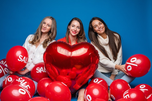 Retrato de tres mujeres muy sonrientes en ropa casual sentado