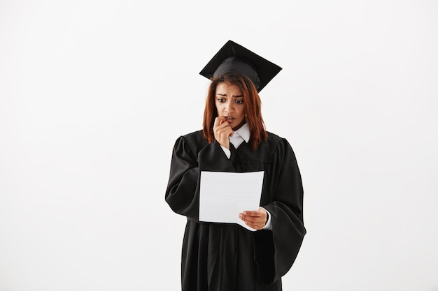 Retrato de triste confundido inseguro descontento mujer africana graduada de la universidad preparándose para su discurso de aceptación o celebración de prueba