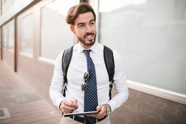 Retrato de un turista masculino feliz con tableta digital