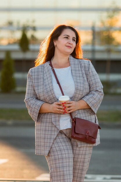 Retrato urbano de mujer sonriente en traje al aire libre