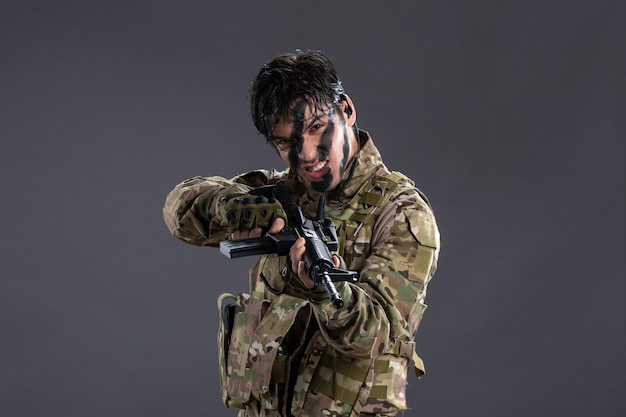 Retrato de valiente soldado luchando durante la operación en la pared oscura