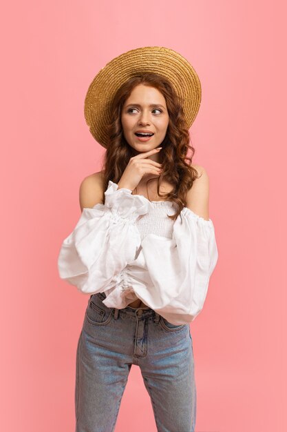 Retrato de verano de alegre dama pelirroja en traje de moda divirtiéndose en rosa