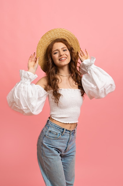 Retrato de verano de alegre dama pelirroja en traje de moda divirtiéndose en rosa