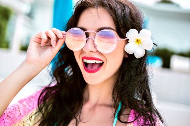 Retrato de verano de hermosa mujer morena de vacaciones de cerca. Emociones excitadas.