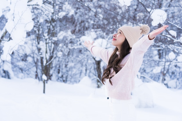 El retrato del viaje feliz de la sonrisa asiática hermosa joven de la mujer y goza con la estación del invierno de la nieve