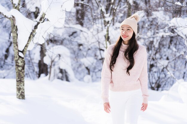 El retrato del viaje feliz de la sonrisa asiática hermosa joven de la mujer y goza con la estación del invierno de la nieve