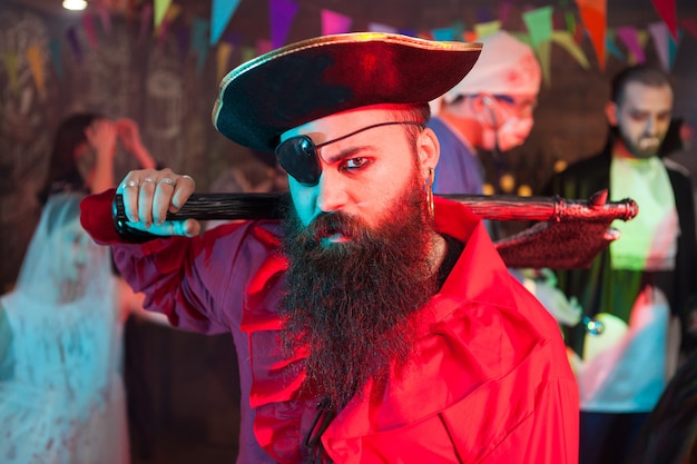 Retrato de vista lateral de hombre guapo con barba en un traje de pirata en la celebración de halloween. Hombre atractivo disfrazado de pirata.