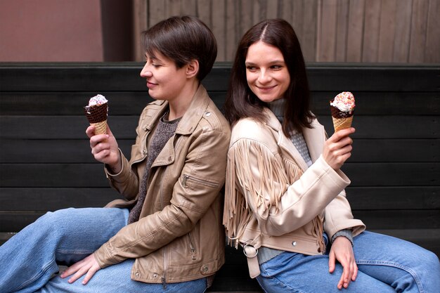 Retratos de amigas al aire libre con conos de helado