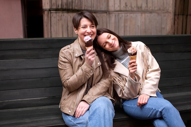 Retratos de amigas al aire libre con conos de helado