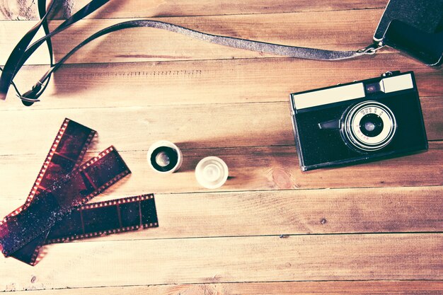 Retro cámara de época y película fotográfica sobre fondo de madera