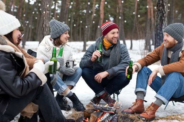 Reunión de amigos sonrientes con botellas de cerveza