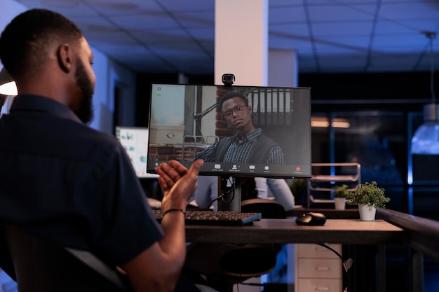 Reunión de empleados de la empresa con un hombre en un chat de teleconferencia remota, usando una cámara web y una computadora para tener una discusión en Internet. Llamada de videoconferencia online para teletrabajo y telecomunicaciones.