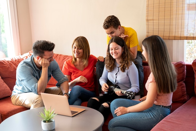 Foto gratuita reunión familiar junto a la computadora portátil en el sofá juntos