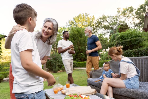 Reunión familiar de plano medio con comida al aire libre