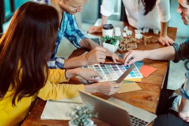 Foto gratuita reunión de negocios creativa con compañeros de trabajo caucásicos y asiáticos discuten con una computadora portátil de papel y felicidad y un alegre fondo de café