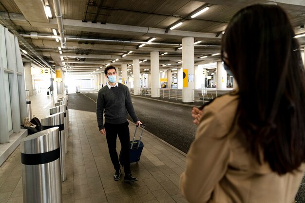 Reunión de pareja de larga distancia de tiro medio en el aeropuerto