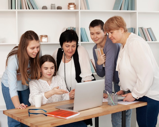 Reunión social femenina mirando una computadora portátil