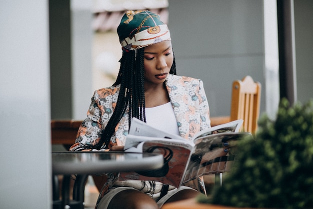 Revista de lectura de mujer afroamericana en un café