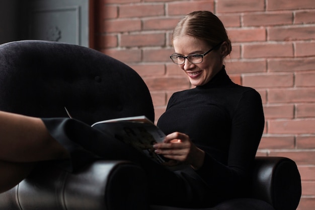 Foto gratuita revista de lectura de mujer sonriente