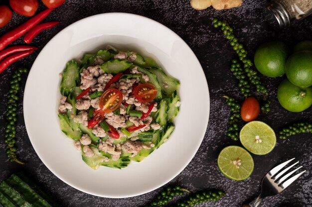 Revuelva el calabacín frito con carne de cerdo picada en un plato blanco