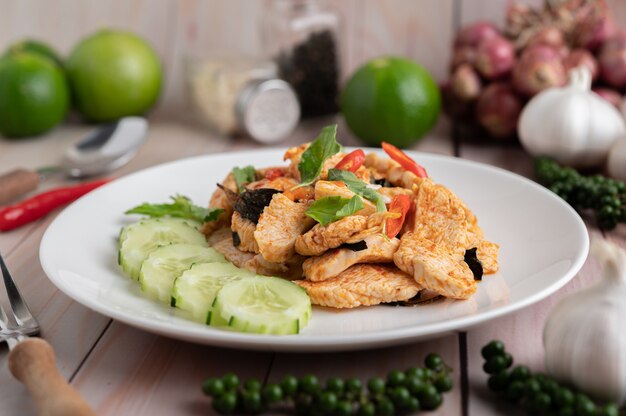 Revuelva la pasta de chile frito con pollo en platos blancos sobre un piso de madera.