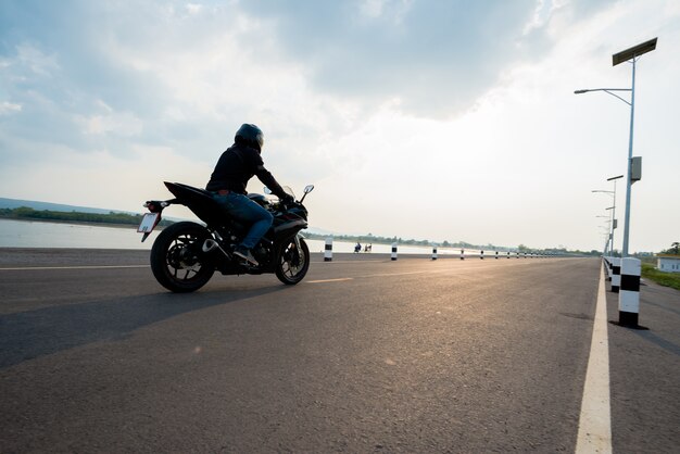 Rider Moto en la carretera. divirtiéndose conduciendo el camino vacío