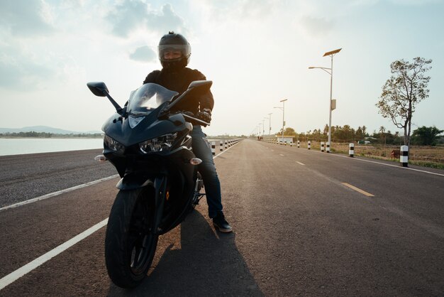 Rider Moto en la carretera. divirtiéndose conduciendo el camino vacío