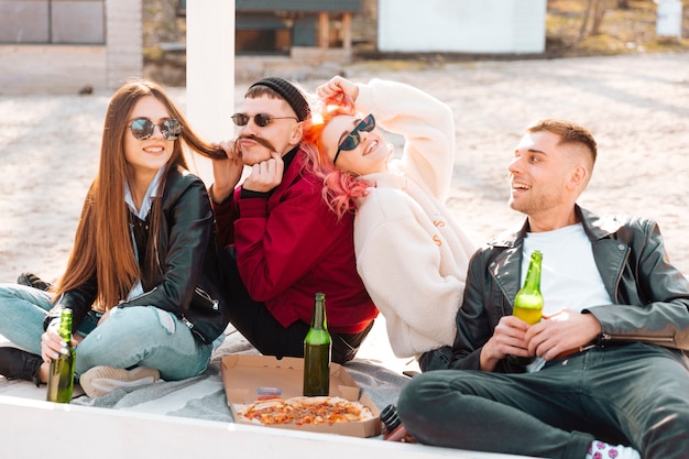 Riendo amigos divirtiéndose juntos en picnic