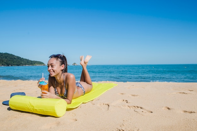 Riendo y bebiendo en la playa