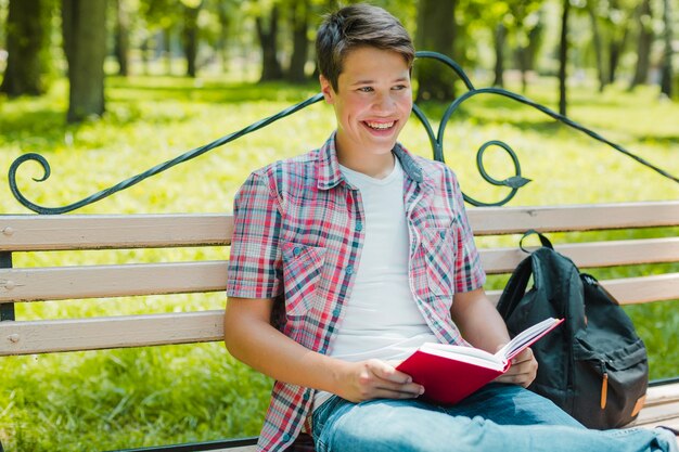 Riendo estudiante posando con el libro