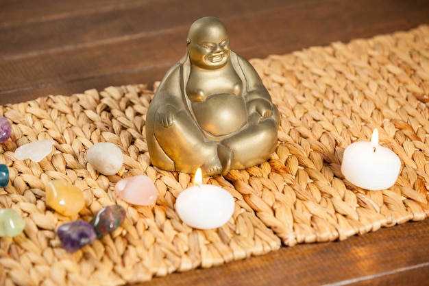 Foto gratuita riendo figurilla de buda, piedra piedras y velas encendidas