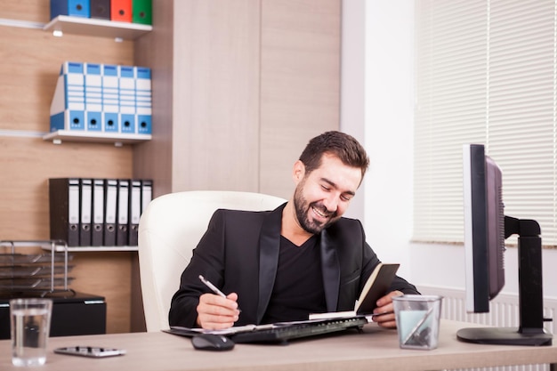 Foto gratuita riendo a hombre de negocios profesional que trabaja en su oficina. empresario en entorno profesional