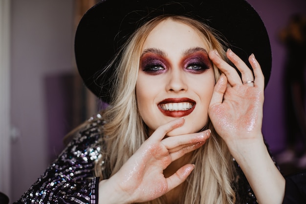 Foto gratuita riendo jocund mujer con pelo largo. foto interior de primer plano de una dama fascinante con maquillaje brillante y brillo de labios.