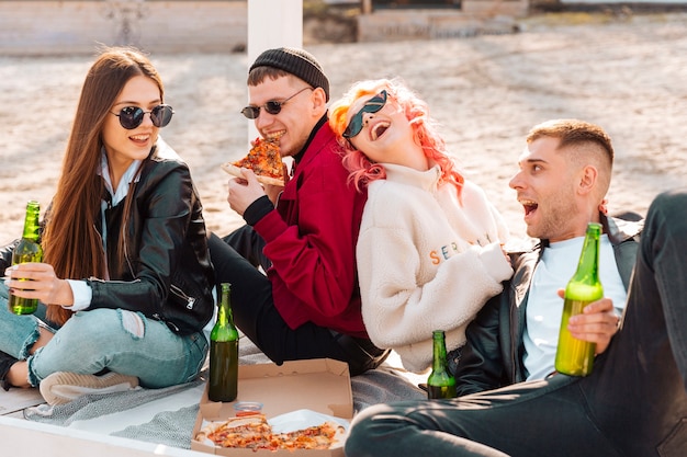 Riendo jóvenes amigos divirtiéndose en picnic